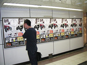 立ち止まってポスターを見入る通行人